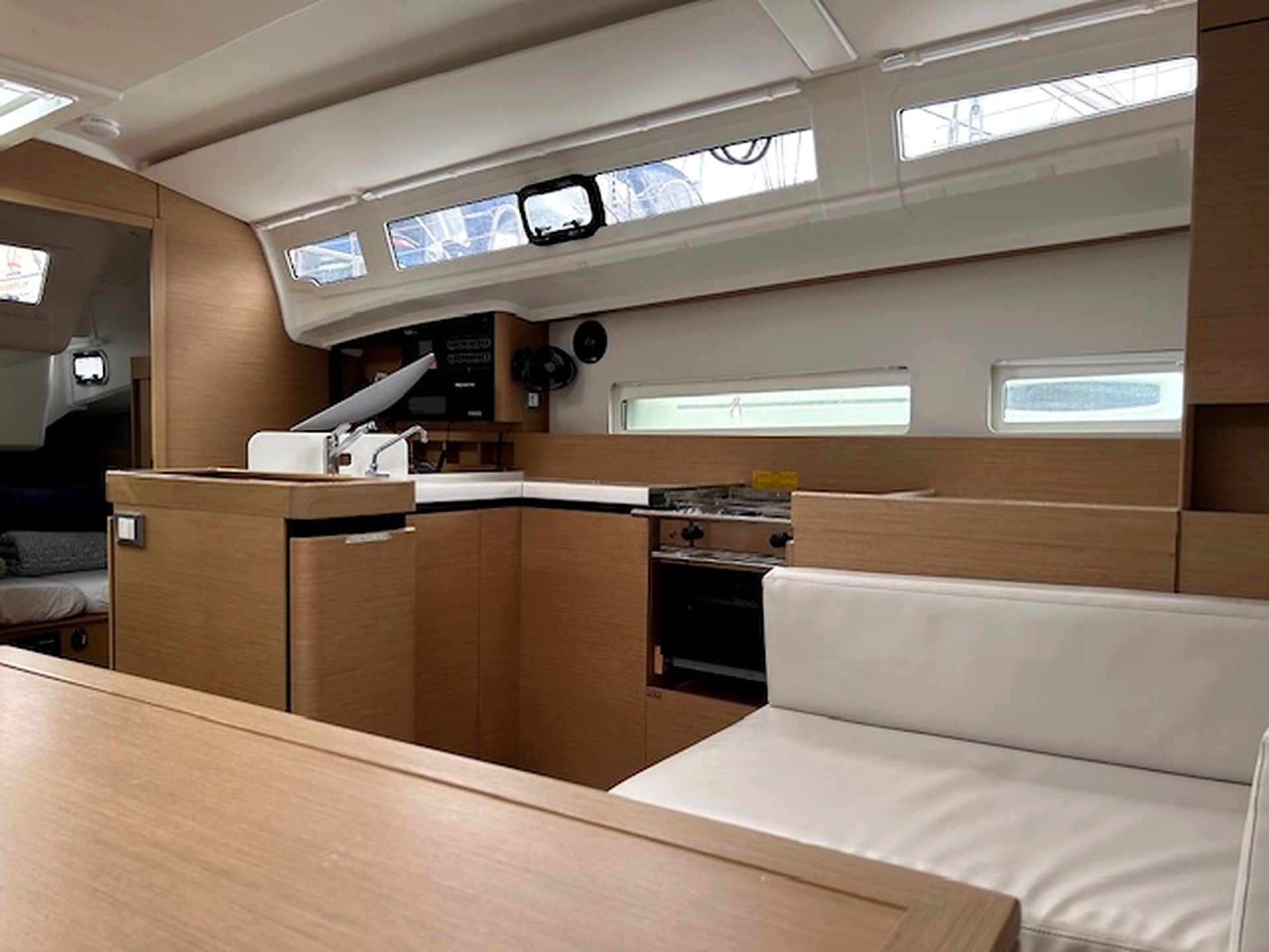 A compact galley with a stove, sink, and a small refrigerator. There is a seating area with a cushioned bench and a table.