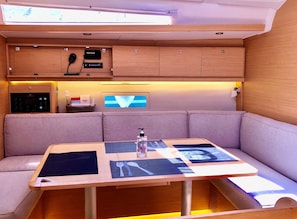 Eine kompakte Küche mit Mikrowelle, einem Raymarine Gerät und einem kleinen Kühlschrank.