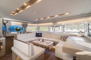 Ein stilvoller Wohnbereich mit einer Couch, einem Couchtisch und großen Fenstern.