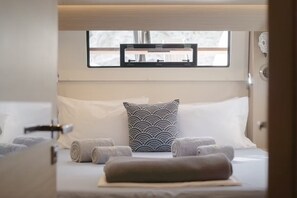 Ein Schlafzimmer mit Bett, Kissen und Handtüchern.