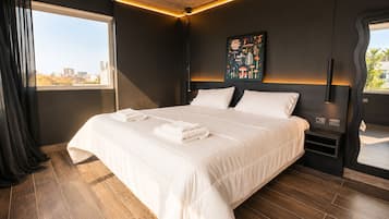 Ein modernes Hotelzimmer mit einem großen Bett, Blick auf die Stadt und einem außergewöhnlichen Wandbild.