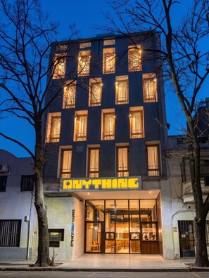 Un edificio de varios pisos con una cafetería llamada 'ANYTHING' en la planta baja.