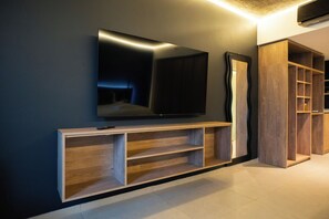 A modern entertainment unit with a flat-screen TV, wooden shelving, and a mirror. - Anything Rooms (Buenos Aires)