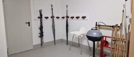A room with white walls, a door, and skis mounted on the wall.