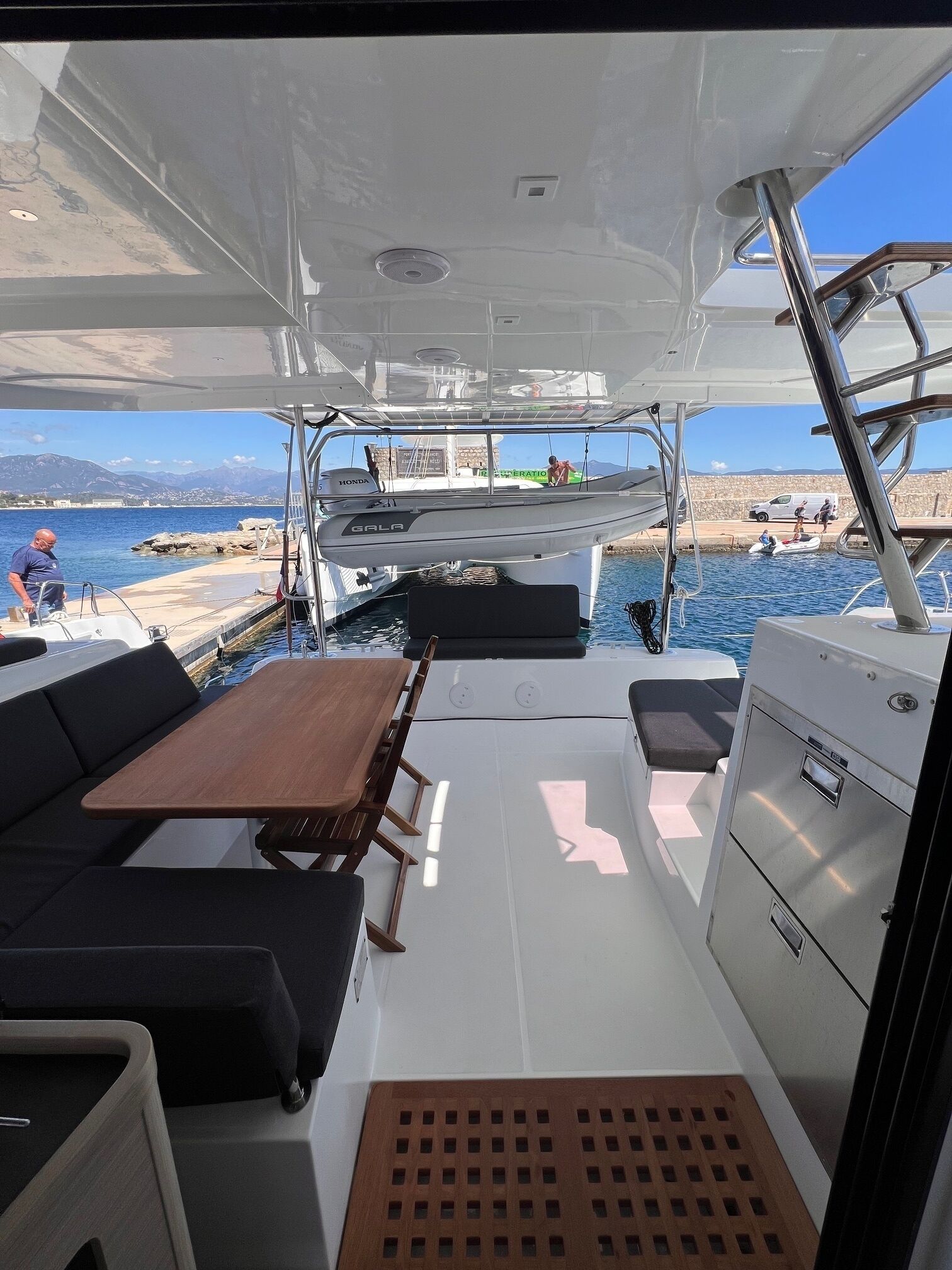 A boat's interior with a table, seating, and a control panel.