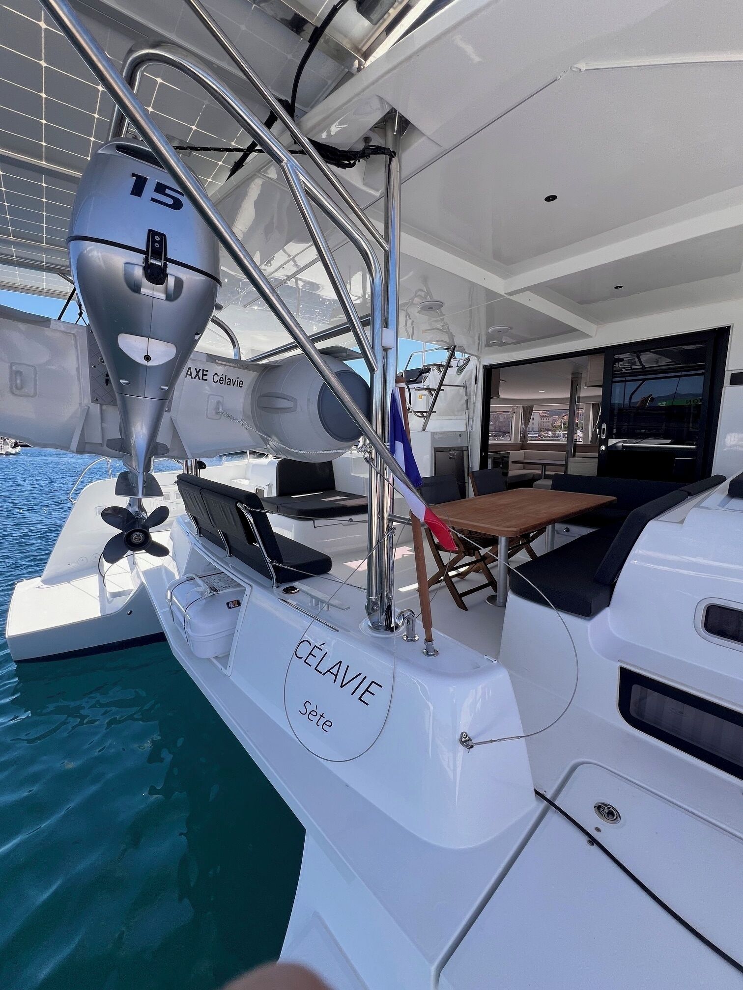 A yacht with a cabin area featuring a table and chairs, a steering wheel, and a winch labeled '15'.