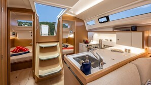 A compact, modern interior with a kitchenette, a dining area, and a seating space with a view. - Sun-Kissed Sailing Adventure in Northern Croatia (Opatija)