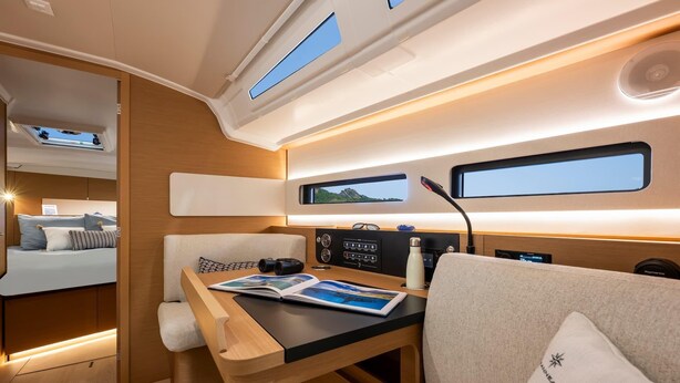 A compact, well-lit interior with a bed, a table with a magazine, a window, and a control panel. - Sun-Kissed Sailing Adventure in Northern Croatia (Opatija)