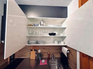 A compact kitchen with white cabinets, a stainless steel sink, and a small countertop area. - Steil Alva Studios Smit Studio, 0002 Steil Alva Studio 2 by Interhome (Lenzerheide)