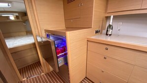 Eine kompakte Küche mit Holzschränken, einem eingebauten Kühlschrank und einer kleinen Arbeitsplatte.