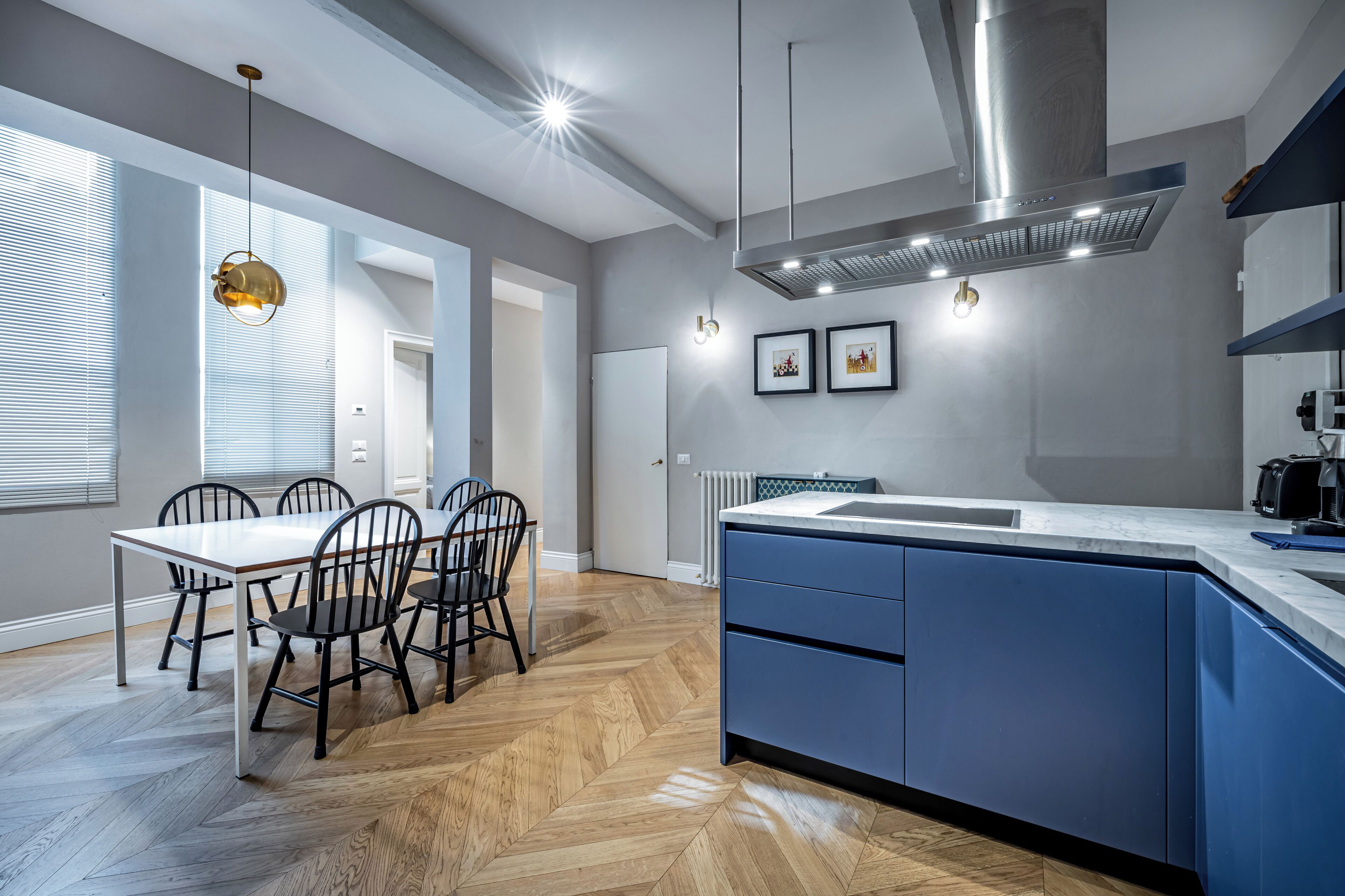 Een moderne keuken met een visgraatvloer, een centraal kookeiland en een ingebouwd fornuis.