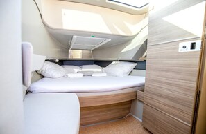 A compact, well-lit interior with a bed, storage drawers, and a window for natural light. - Sun-Kissed Sailing Adventure in Northern Croatia (Opatija)
