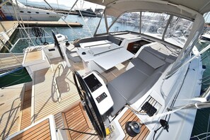A boat deck with a control station, seating area, and a view of the marina. - Sun-Kissed Sailing Adventure in Zadar, Croatia (Zadar)