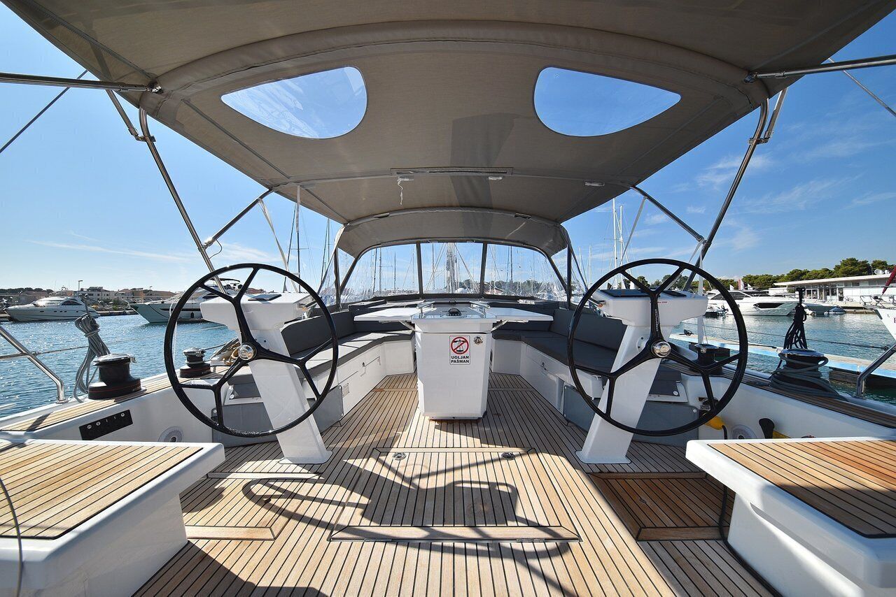 Un pont de bateau équipé de deux roues de barre, d’une console centrale et d’un auvent au-dessus.