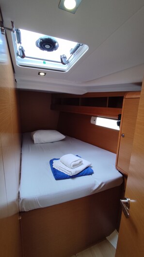 A compact cabin with a single bed, a skylight, and a small window. - Sun-Kissed Sailing Adventure in the Sporades Islands from Volos, Thessaly (Volos)