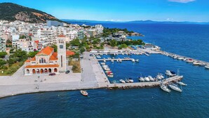 Un pueblo costero con una iglesia destacada, un puerto deportivo y edificios residenciales.