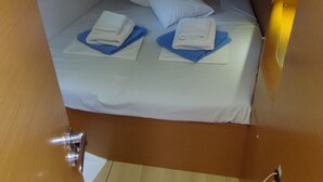 A compact cabin with a small bed, pillows, and neatly folded towels. - Sun-Kissed Sailing Adventure in the Sporades Islands from Volos, Thessaly (Volos)