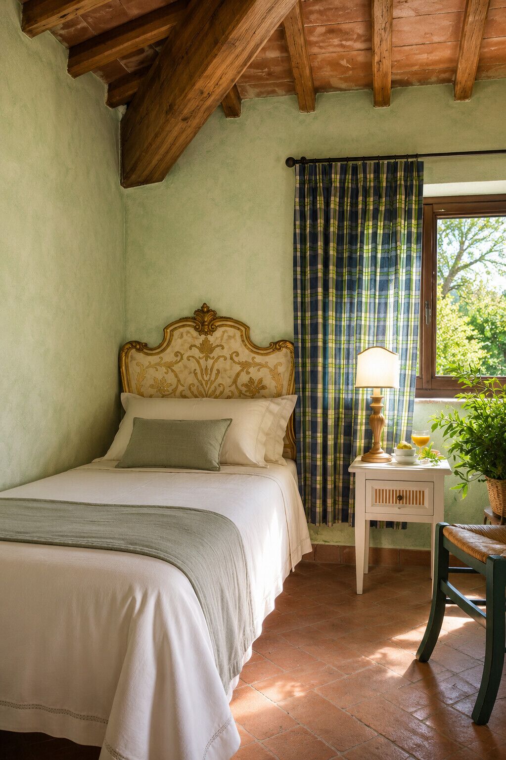 A bedroom with a bed, a nightstand with a lamp, a window with curtains, and a view of greenery outside.