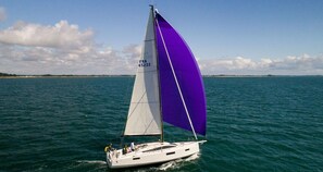 A sailboat with a purple sail on the water.