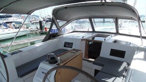A boat's interior with a steering wheel, control panel, and seating area. - Sun-Kissed Sailing Adventure in Phuket (Mai Khao)