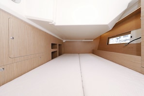A compact, well-lit interior with a bed, wooden paneling, and a window providing natural light. - Sun-Kissed Sailing Adventure in Zadar, Croatia (Zadar)