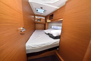 A compact, well-lit interior with a bed, a small window, and a ceiling-mounted light fixture. - Sun-Kissed Sailing Adventure in Zadar, Croatia (Zadar)