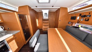 Een compact RV-interieur met een kitchenette, een eethoek en een kleine badkamer.