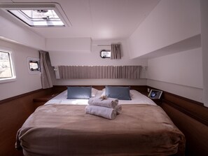 A hotel room with a large bed, a window, a skylight, and a bedside table. - Dubrovnik Delight: A Sun-Kissed Sailing Experience (Komolac)