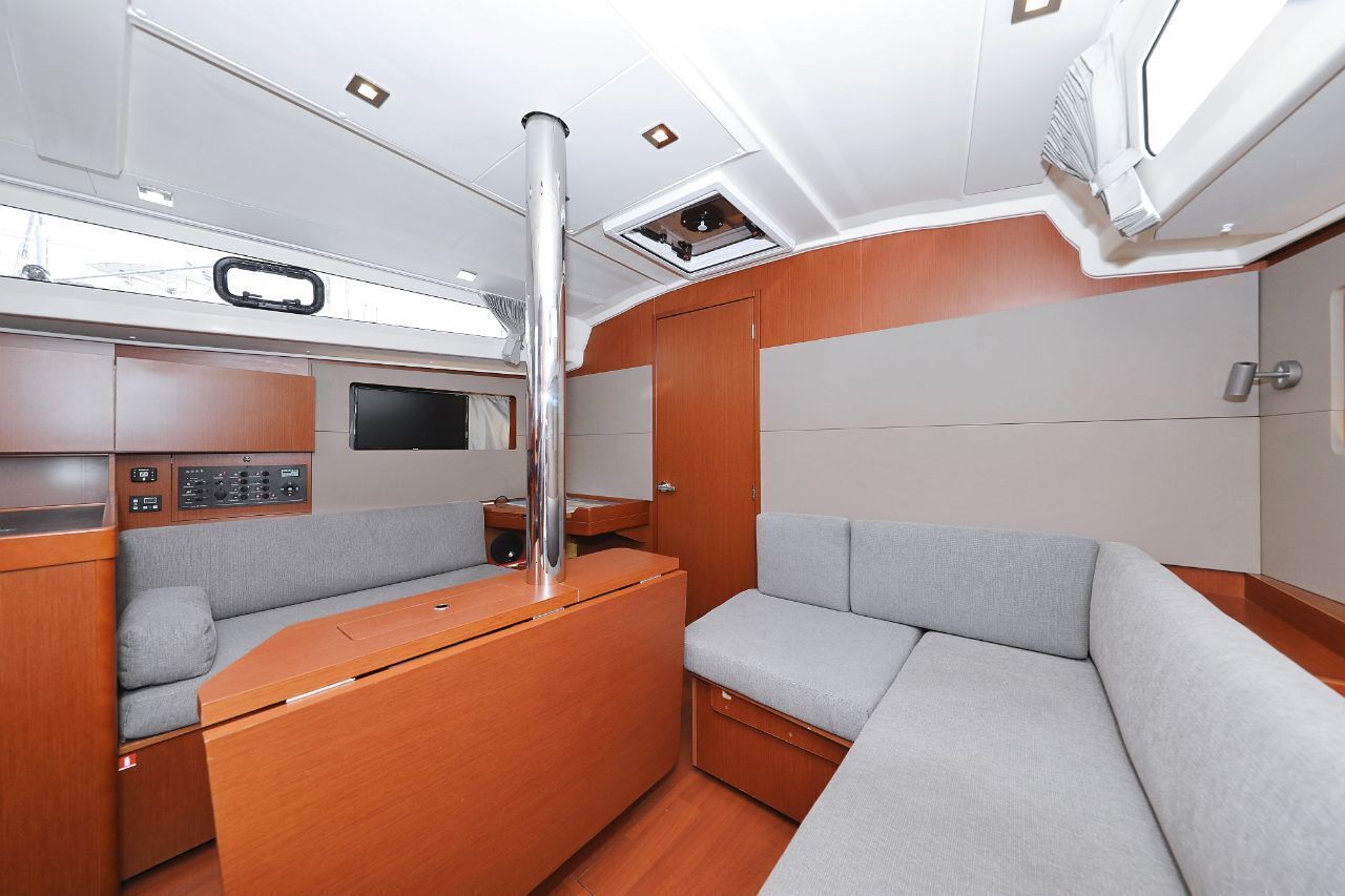 A compact, modern interior with a control panel, seating area, and a window.