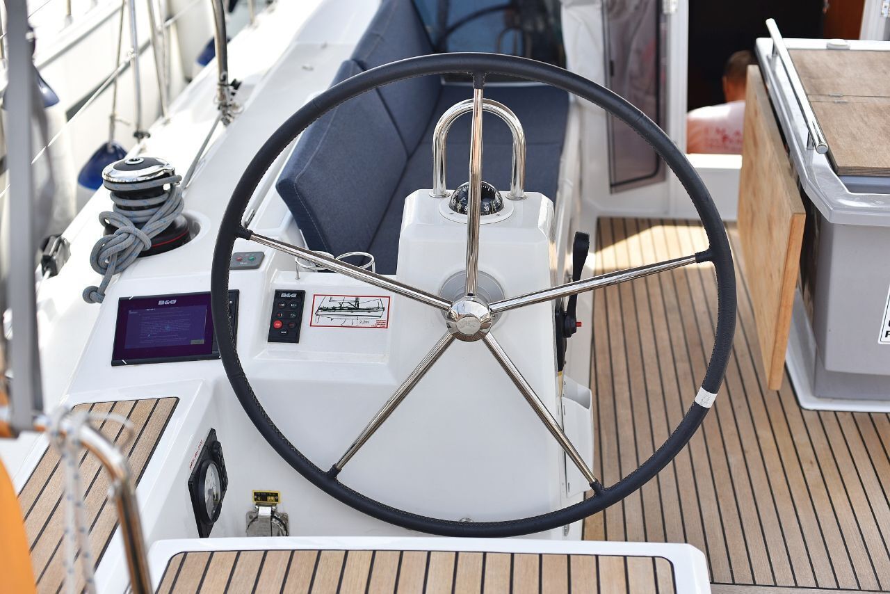 Posto di guida di una barca con timone, pannello di controllo e winch.