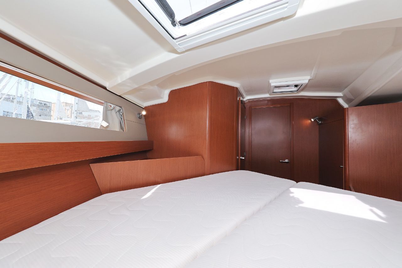 Un interior reducido con una cama, una ventana y una puerta.