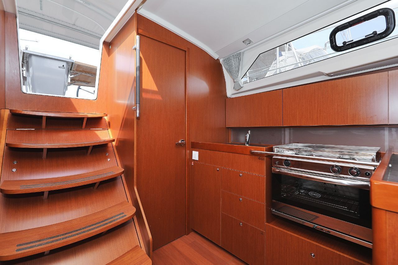 Une petite cuisine fonctionnelle avec des meubles en bois, une cuisinière et une petite fenêtre.