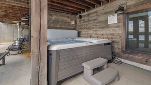 Uma cabana de madeira com banheira de hidromassagem, área de estar externa e janela.