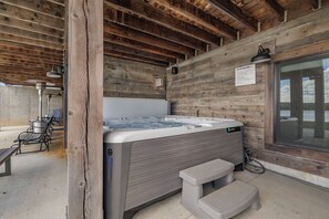 Eine Holzhütte mit Whirlpool, Sitzgelegenheit im Freien und einem Fenster.