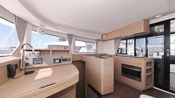 A modern kitchen with a central island, built-in oven, and a view of the marina.