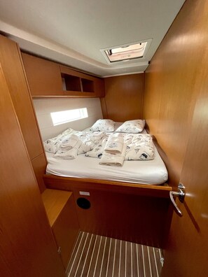 Ein gemütliches Blockhaus mit Bett, kleinem Fenster und Deckenleuchte.