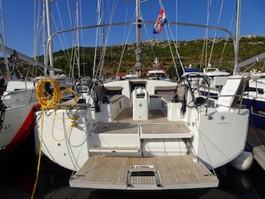 A boat deck with a steering wheel, control panel, and a flag. - Sun-Kissed Sailing Adventure in Sibenik, Croatia (Primošten)