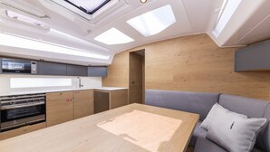 A compact kitchen with a microwave, oven, and wooden cabinets. - Sun-Kissed Sailing Adventure in Zadar, Croatia (Zadar)