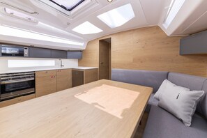A compact kitchen with a microwave, oven, and wooden cabinets. - Sun-Kissed Sailing Adventure in Zadar, Croatia (Zadar)