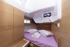 A compact, single-bed RV with a wooden interior, a small window, and a power outlet. - Sun-Kissed Sailing Adventure in Zadar, Croatia (Zadar)