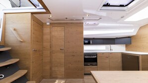 A compact kitchen with wooden cabinetry, a built-in oven, and a skylight. - Sun-Kissed Sailing Adventure in Zadar, Croatia (Zadar)