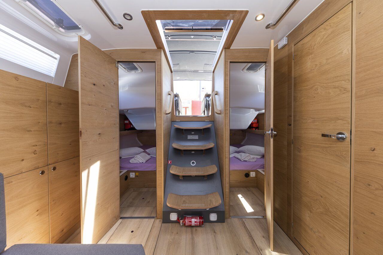 Ein kompaktes Wohnmobil-Interieur mit einer zentralen Schlafkoje, Stauraumschränken und einem Dachfenster.