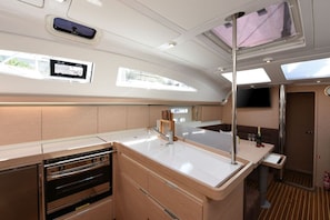 A compact galley with a sink, stove, and storage cabinets. - Sun-Kissed Sailing Adventure in Zadar, Croatia (Zadar)
