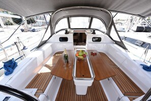 A boat's deck with a central table, seating, and a view of the marina. - Sun-Kissed Sailing Adventure in Zadar, Croatia (Zadar)