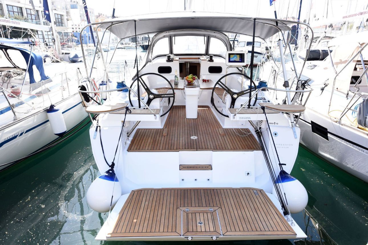 A boat deck with two steering wheels, a central console, and a wooden deck.