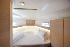 A compact, well-lit cabin with a bed, a small window, and a ceiling light. - Sun-Kissed Sailing Adventure in Zadar, Croatia (Zadar)