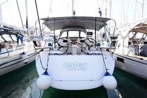 A boat named 'Popaj Zadar' docked at a marina with other boats, a steering wheel, and a small screen. - Sun-Kissed Sailing Adventure in Zadar, Croatia (Zadar)