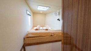 Une petite pièce, de taille modeste, comprenant un lit, un luminaire au plafond et un appareil fixé au mur.