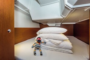 A compact cabin with a bunk bed, a plush toy, and neatly stacked pillows. - Sun-Kissed Sailing Adventure in Zadar, Croatia (Biograd na moru)