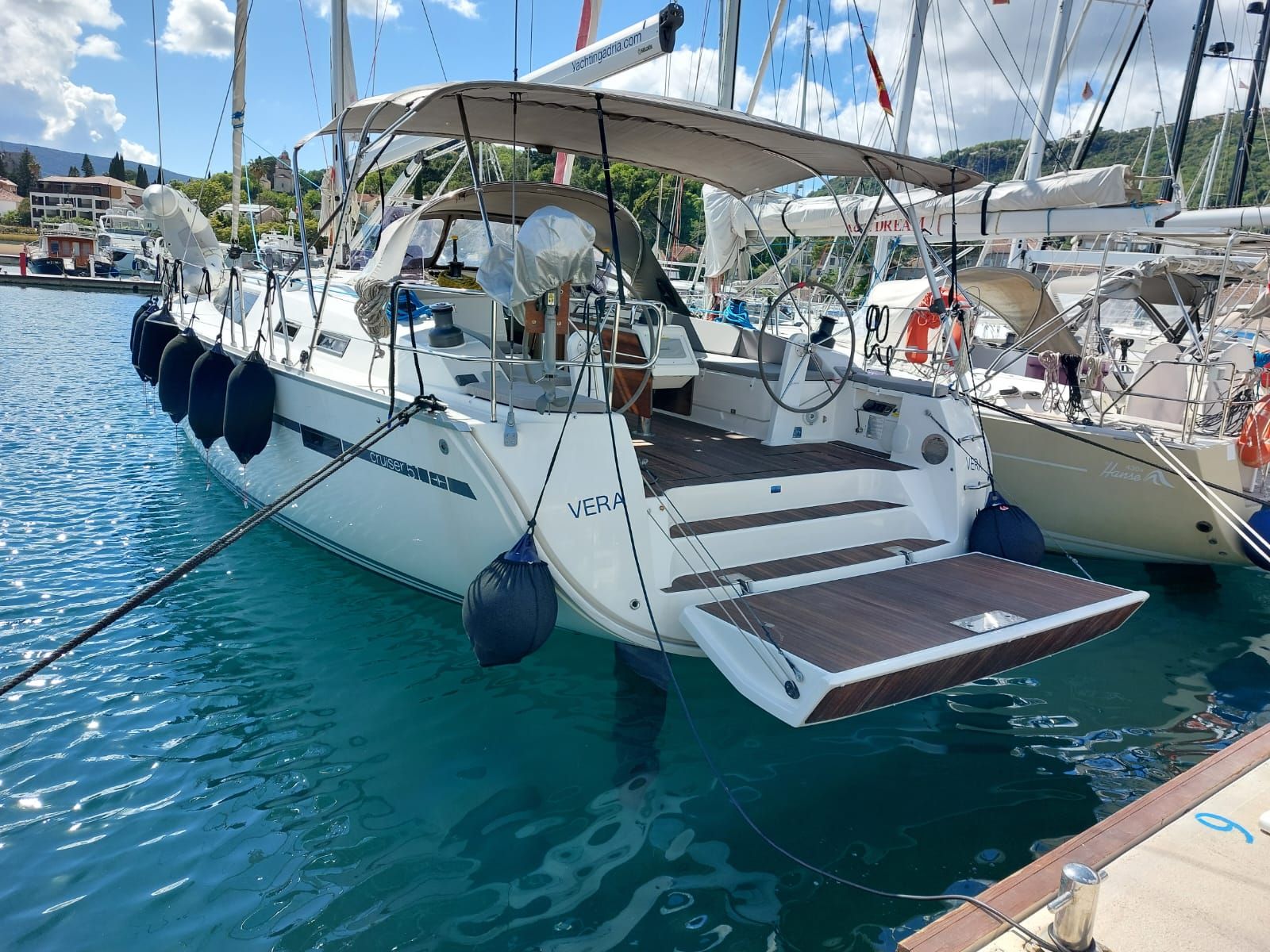 Un puerto deportivo con varios yates amarrados, que cuenta con una zona cubierta y una pequeña plataforma abierta.